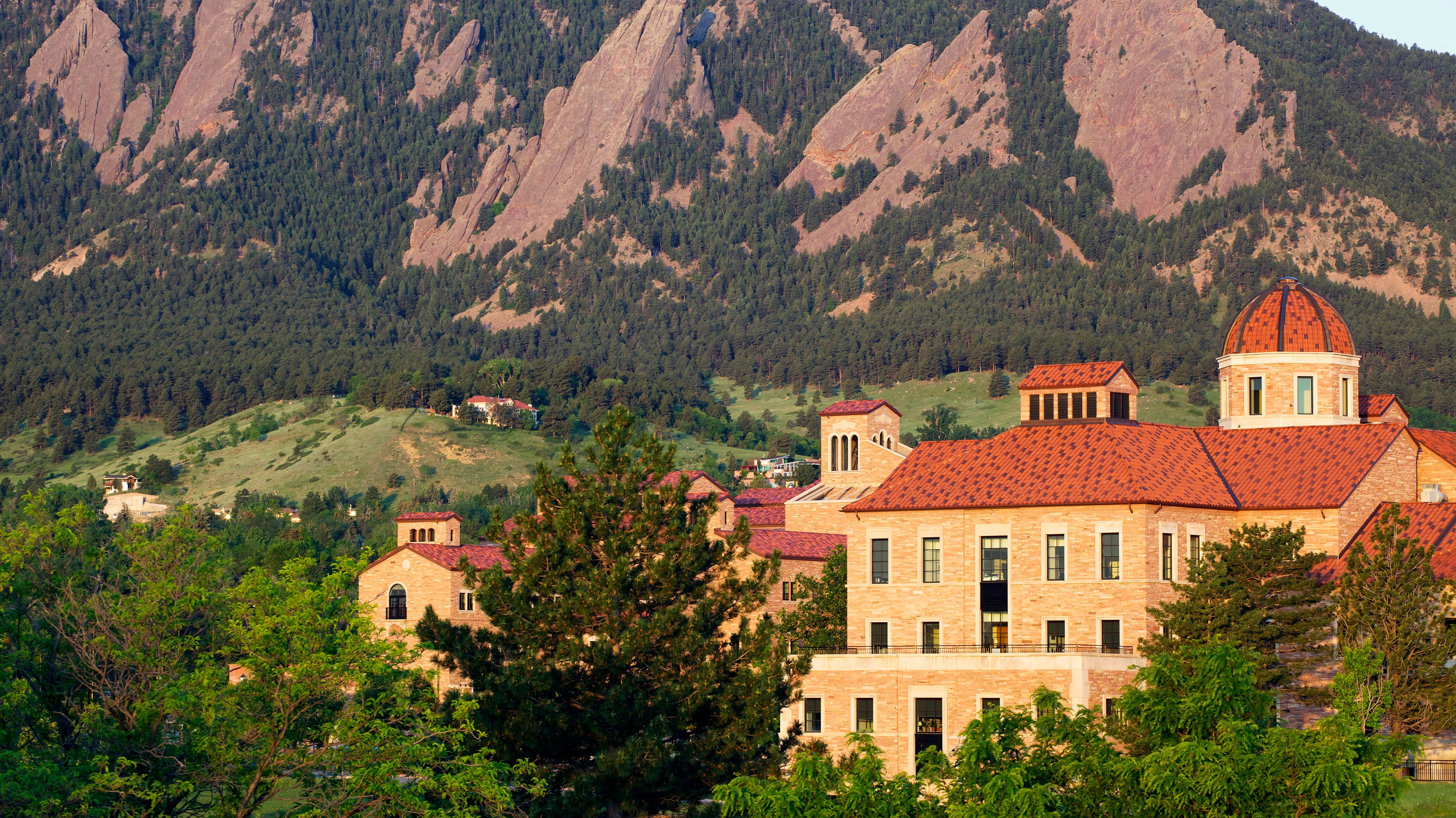 A photo of red brick buildings with mountains in the background